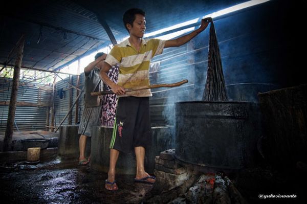 Proses melepaskan lilin batik dari kain dengan cara direbus