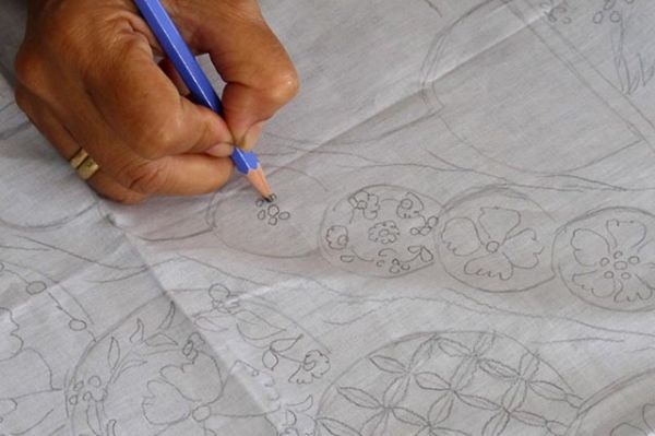 menggambar motif batik tulis diatas kain menggunakan pensil